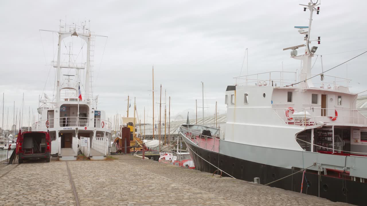 Boats docked at a cobblestone pier in a harbor