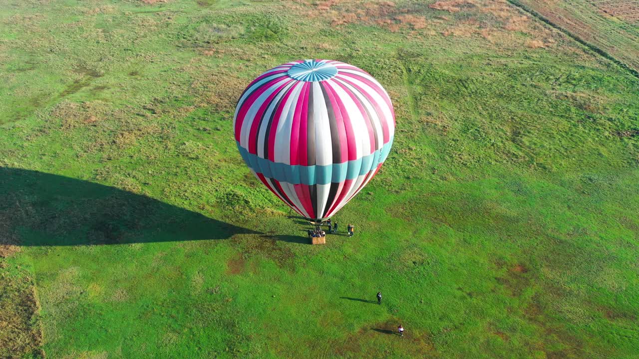 vista aérea del globo aerostático listo para despegar de un campo verde