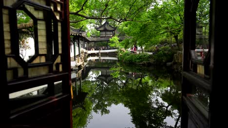 tranquil view of the humble administrator's garden through a window with reflections in a serene pond