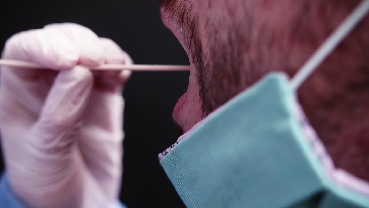 Primo piano di un uomo che riceve un tampone faringeo per un test medico