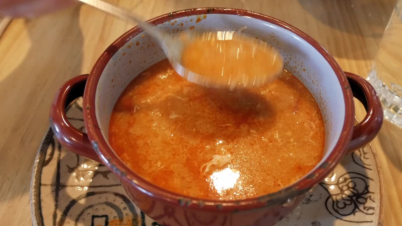 Sopa Castellana being stirred in a rustic bowl, showing rich and flavorful soup