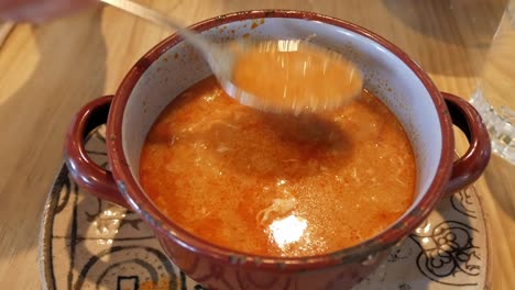 Sopa Castellana being stirred in a rustic bowl, showing rich and flavorful soup