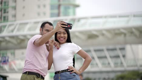 Feliz-Pareja-Joven-Posando-Para-Selfie-En-La-Calle