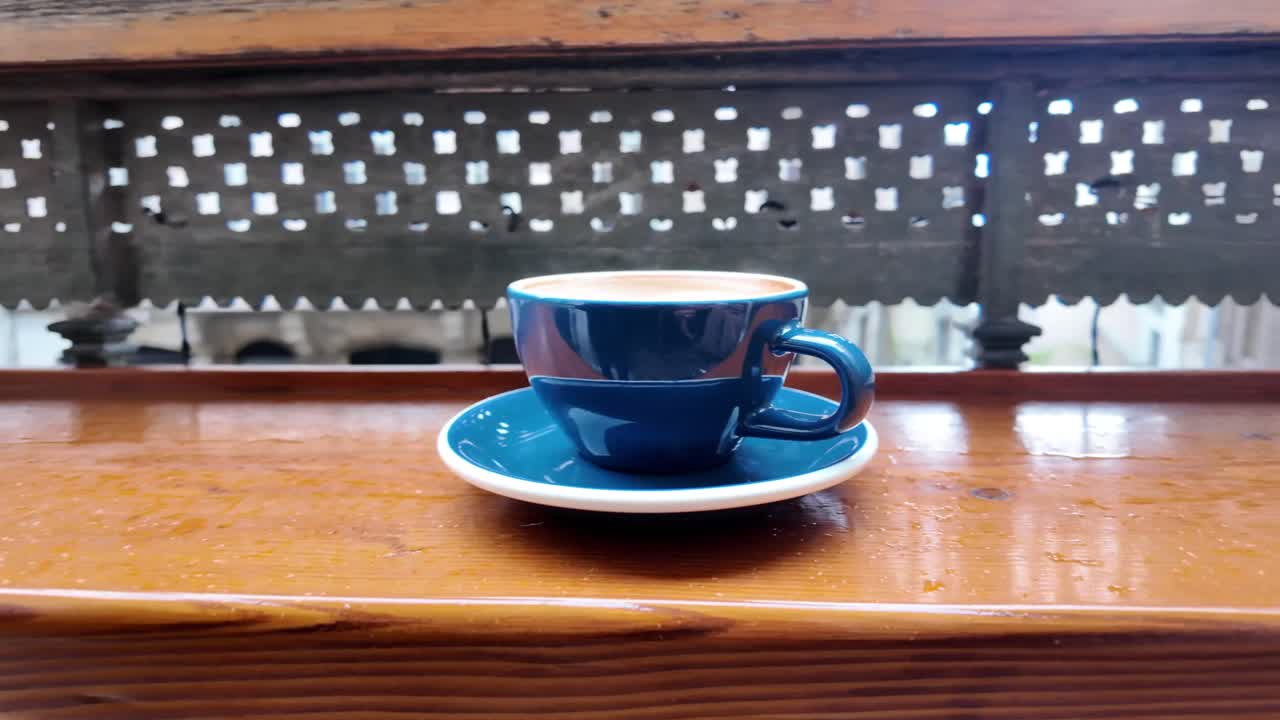 窓のそばでコーヒーを飲む