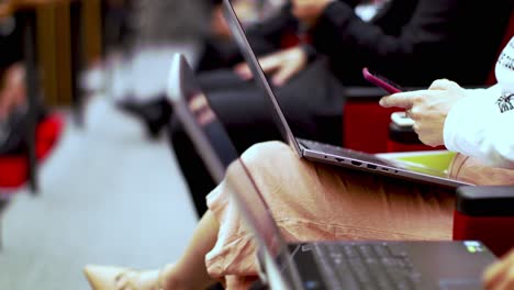 unrecognizable people in formal wear using laptops during conference