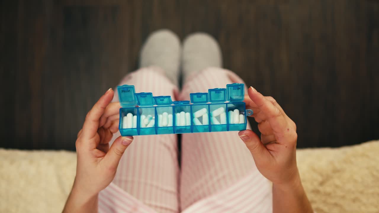 알약 조직기와 함께 약을 복용하는 여성