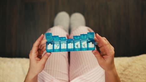 mujer que toma medicamentos con organizador de pastillas