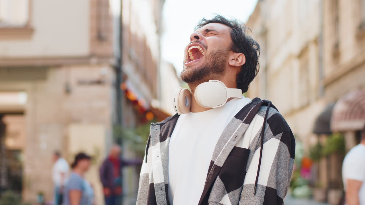 젊은 인디언 남자가 스트레스, 긴장 문제로 소리를 지르며 시내 거리에서 공포를 느다.