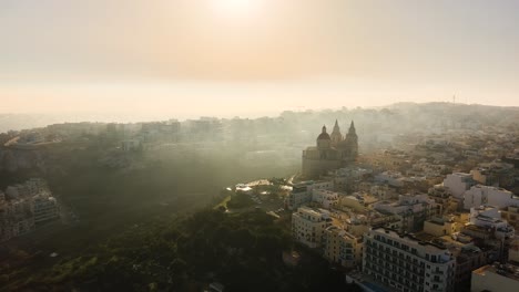 drone sparato volando verso la chiesa di mellieha su una collina in una mattinata molto nebbiosa a malta