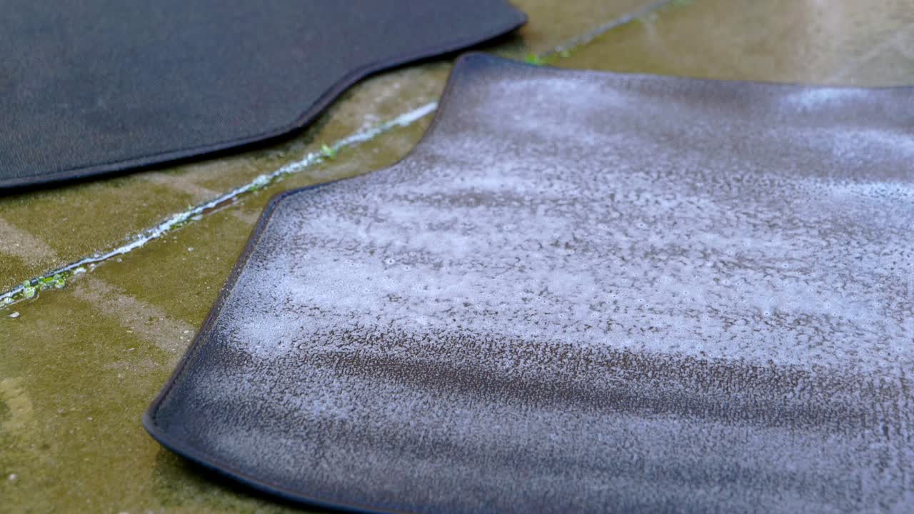 Applying cleaner to small carpet foot with a blue pressure sprayer - extreme close up, tight shot