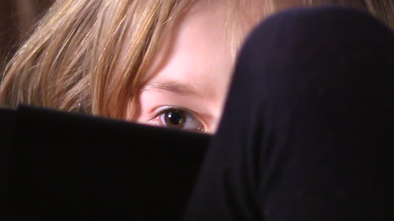 young blond girl in deep focus on her tablet CLOSE UP