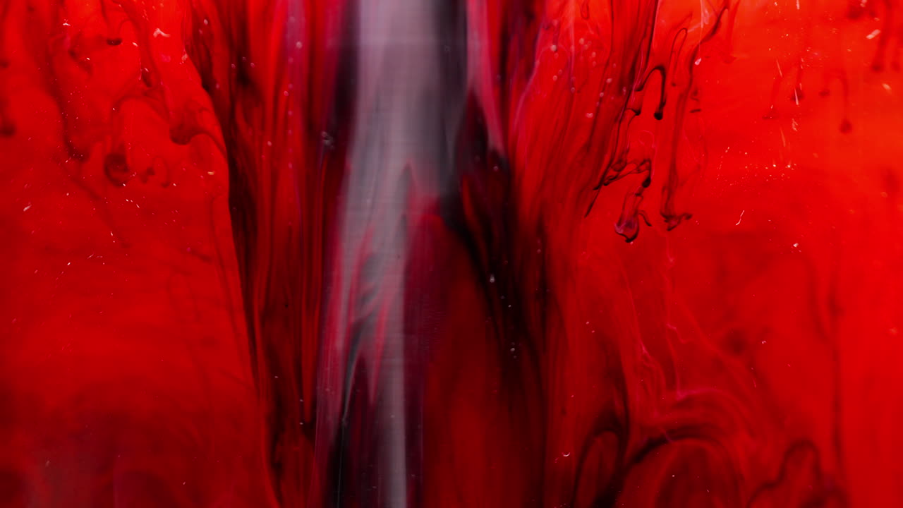 Vivace inchiostro rosso che si diffonde nell'acqua, creando texture macro artistiche