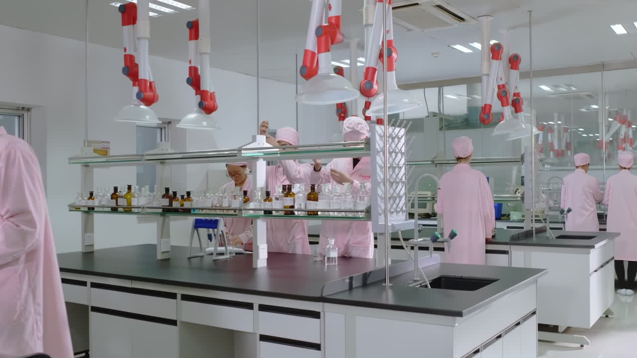Research scientists work in a cleanroom environmental facility laboratory, with lab coats safety conducting biological experiment on Cell culture essay with help of high tech, test tubes