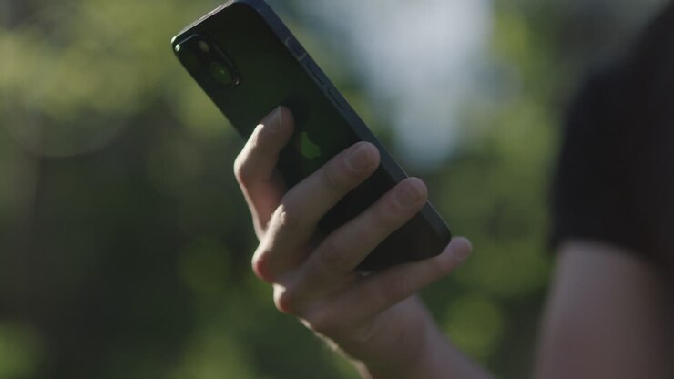 Nahaufnahme einer Person, die ein Handy hält