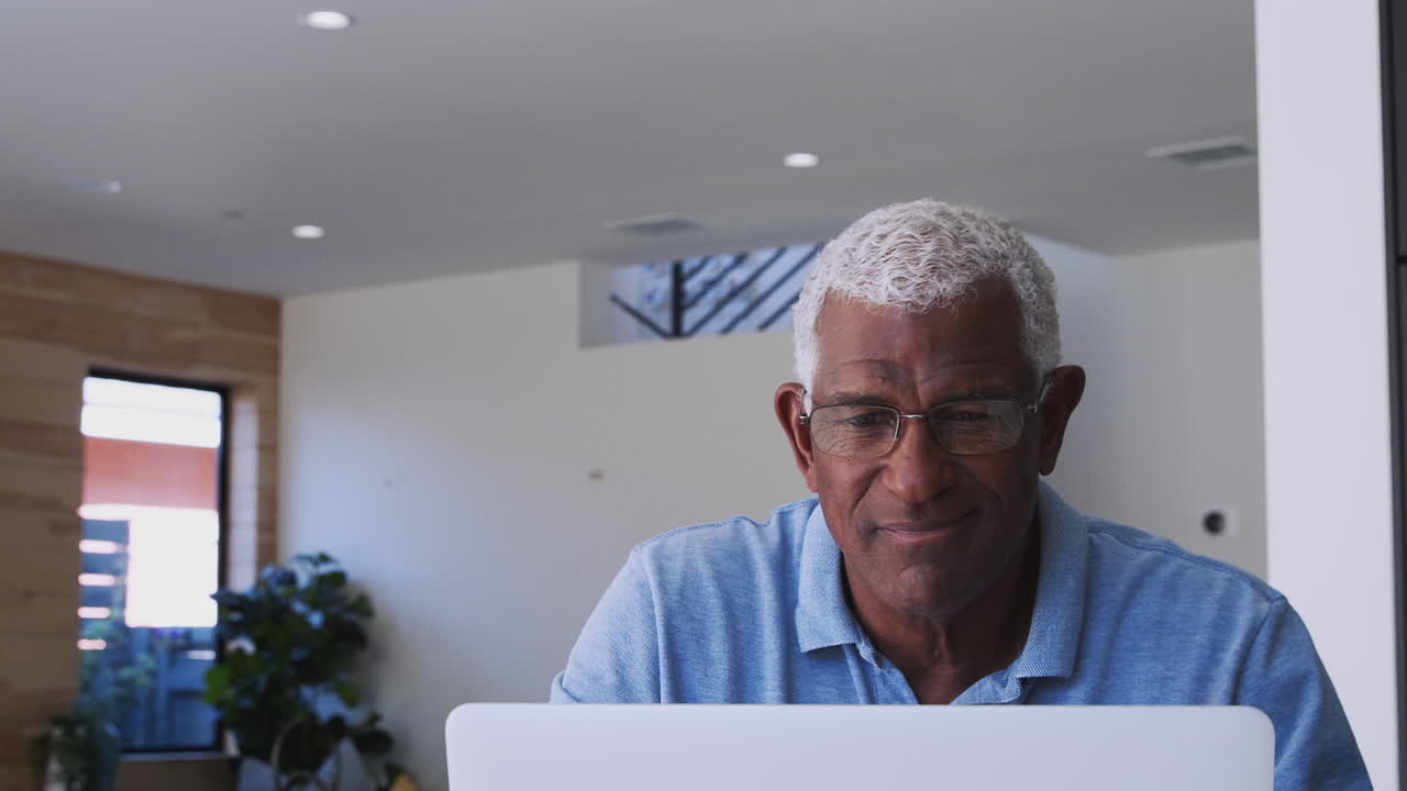 Senior African American Man Using Laptop To Check Finances At Home