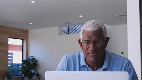 Senior African American Man Using Laptop To Check Finances At Home