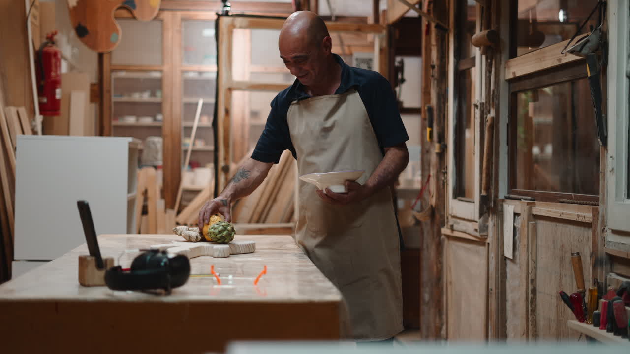 Man in Apron Arranging Fresh Artichoke and Fruit on Wooden Table