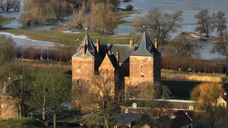 drone footage of slot loevestein flooded in rain waters along the waal river in varik, gelderland, netherlands