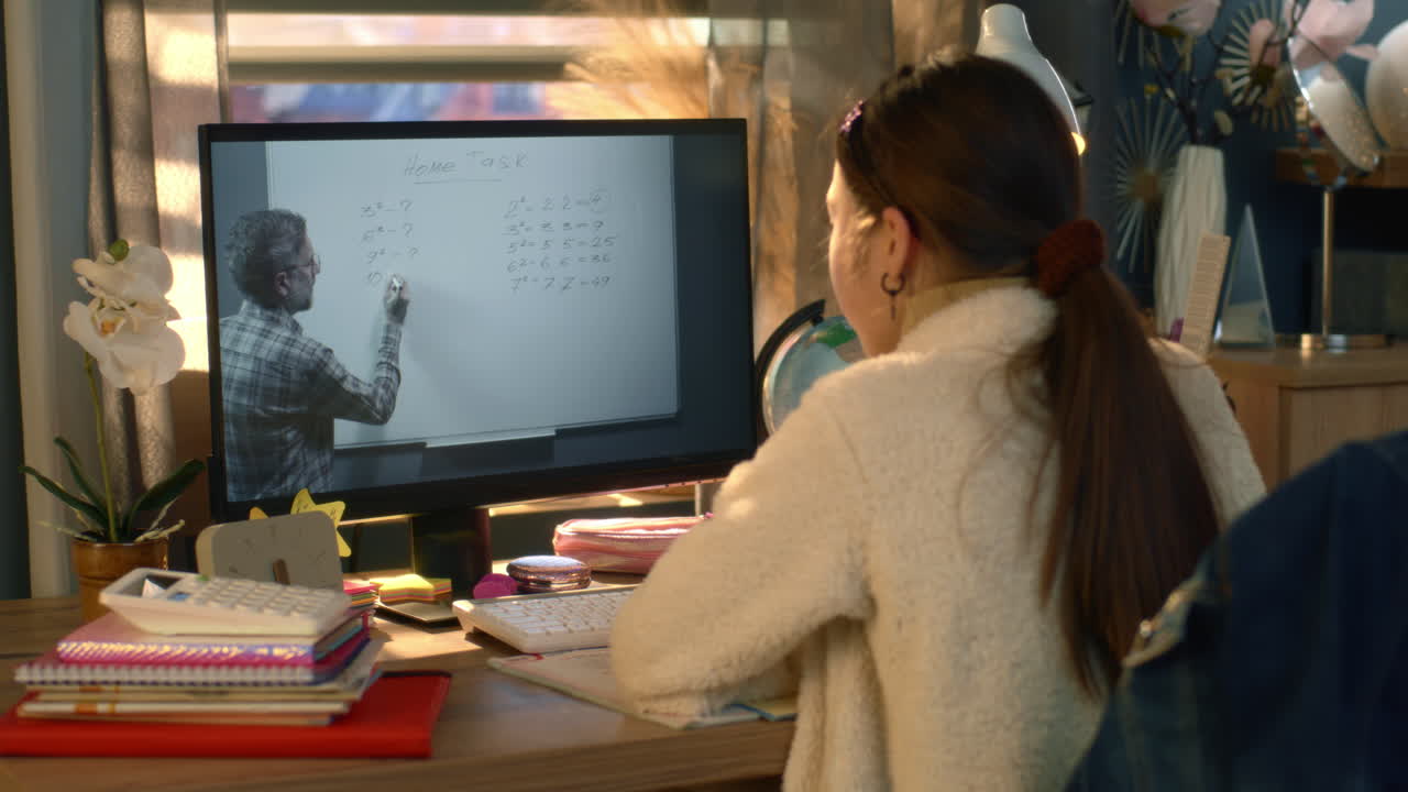 Student learning online at home with teacher on screen