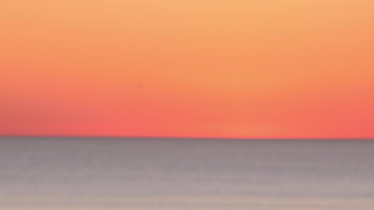 vista bokeh del paisaje marino al atardecer con cielo naranja