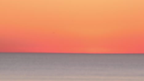 vista bokeh del paisaje marino al atardecer con cielo naranja