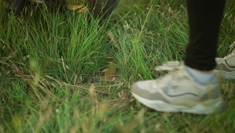 close-up of a person wearing sneakers jumping on a grassy field near a bike