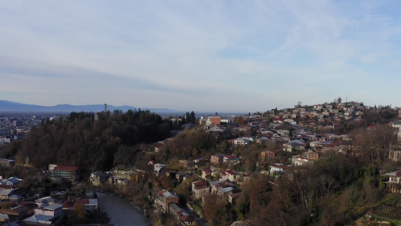 vuelo aéreo sobre la ciudad de kutaisi con montañas nevadas y río