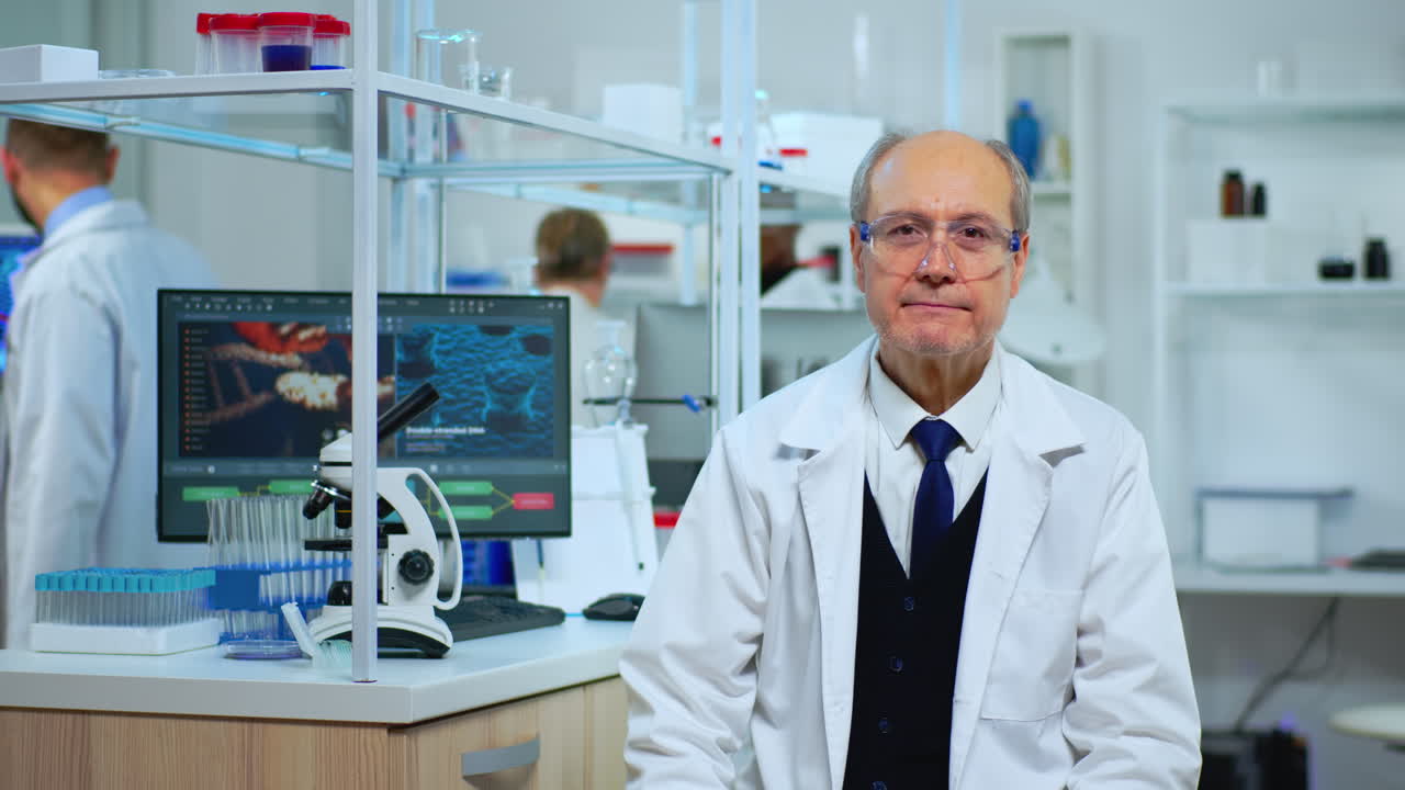 Senior biochemist sitting in lab looking satisfied at camera