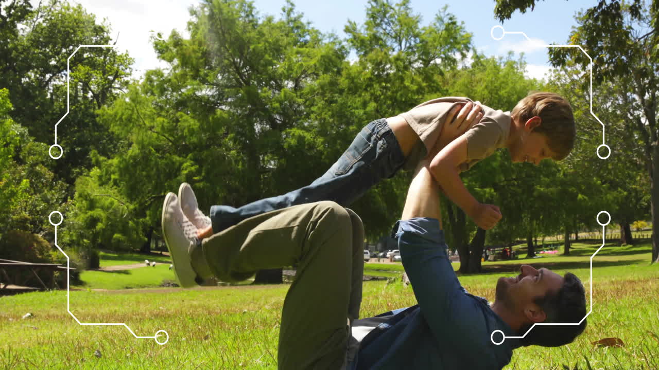 padre levantando a su hijo con las piernas en el parque, rodeado de animación de procesamiento de datos