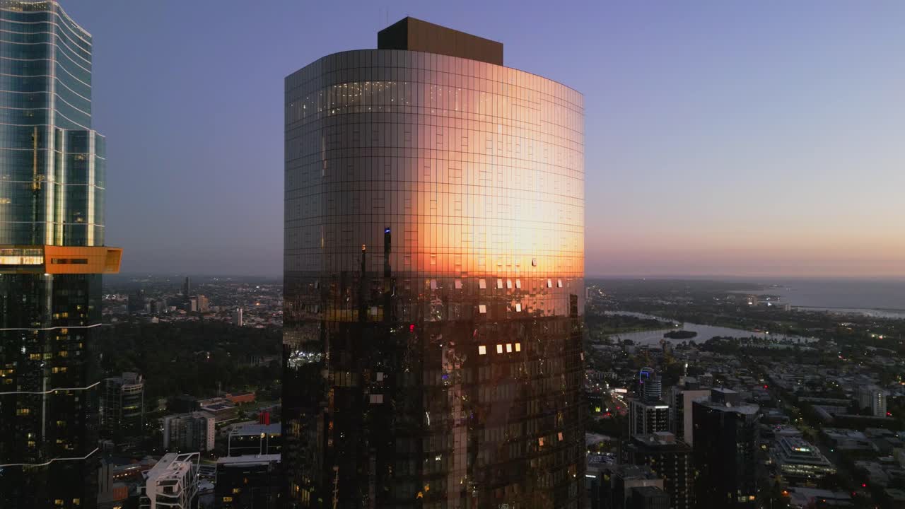 video aéreo del sol reflejado en un edificio de vidrio en la hora azul