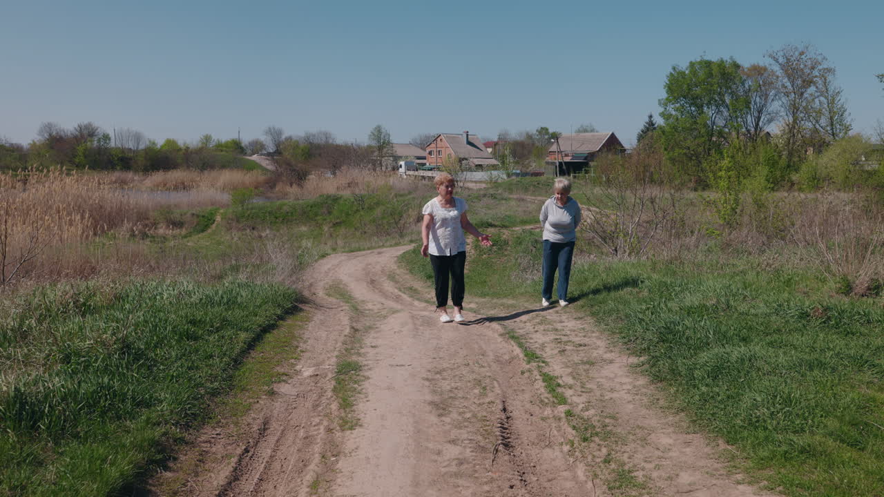 Two Elderly Women Walking on a Country Road