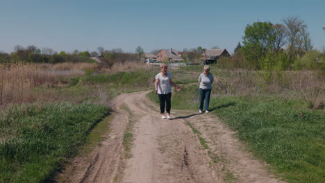 two elderly women walking on a country road