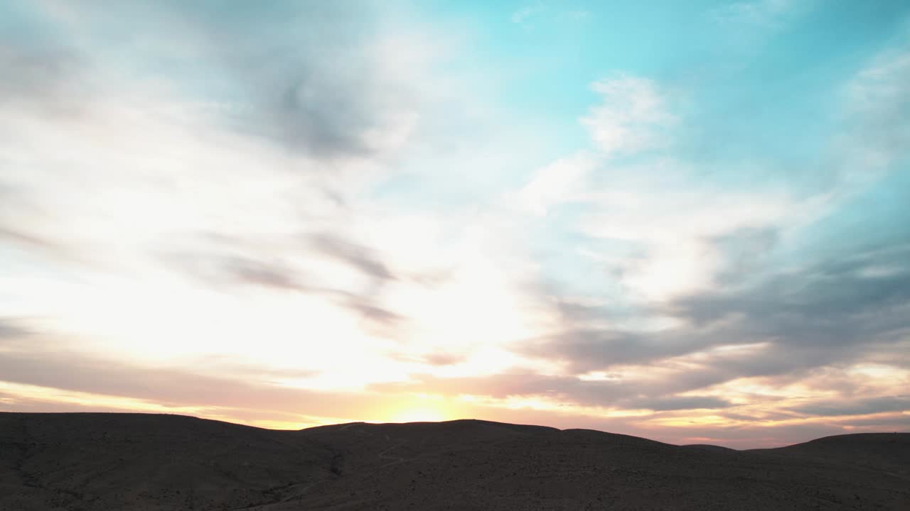 하늘이 이스라엘의 사막 모래 언덕 위로 여러 가지 색으로 칠해지는 아름다운 일몰의 저속