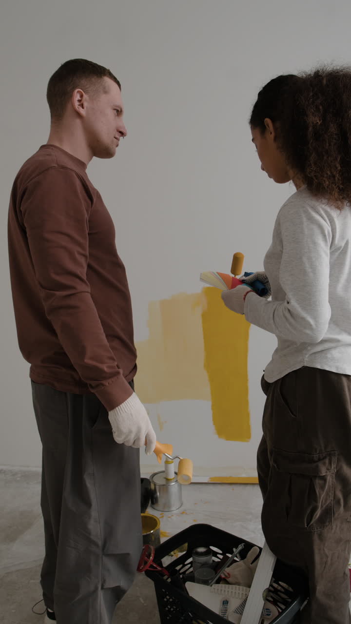 pareja pintando una pared juntos