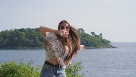 mujer feliz bailando junto al mar