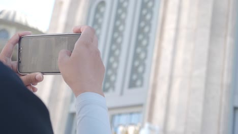 woman taking picture of a mosque