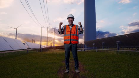 full body of asian male engineer with safety helmet screaming goal celebrating working with solar panel and wind turbines