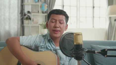 Boy Singing and Playing Guitar at Home