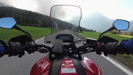 pov biker rides on motorbike by scenic green mountain road, swiss alp, moto trip