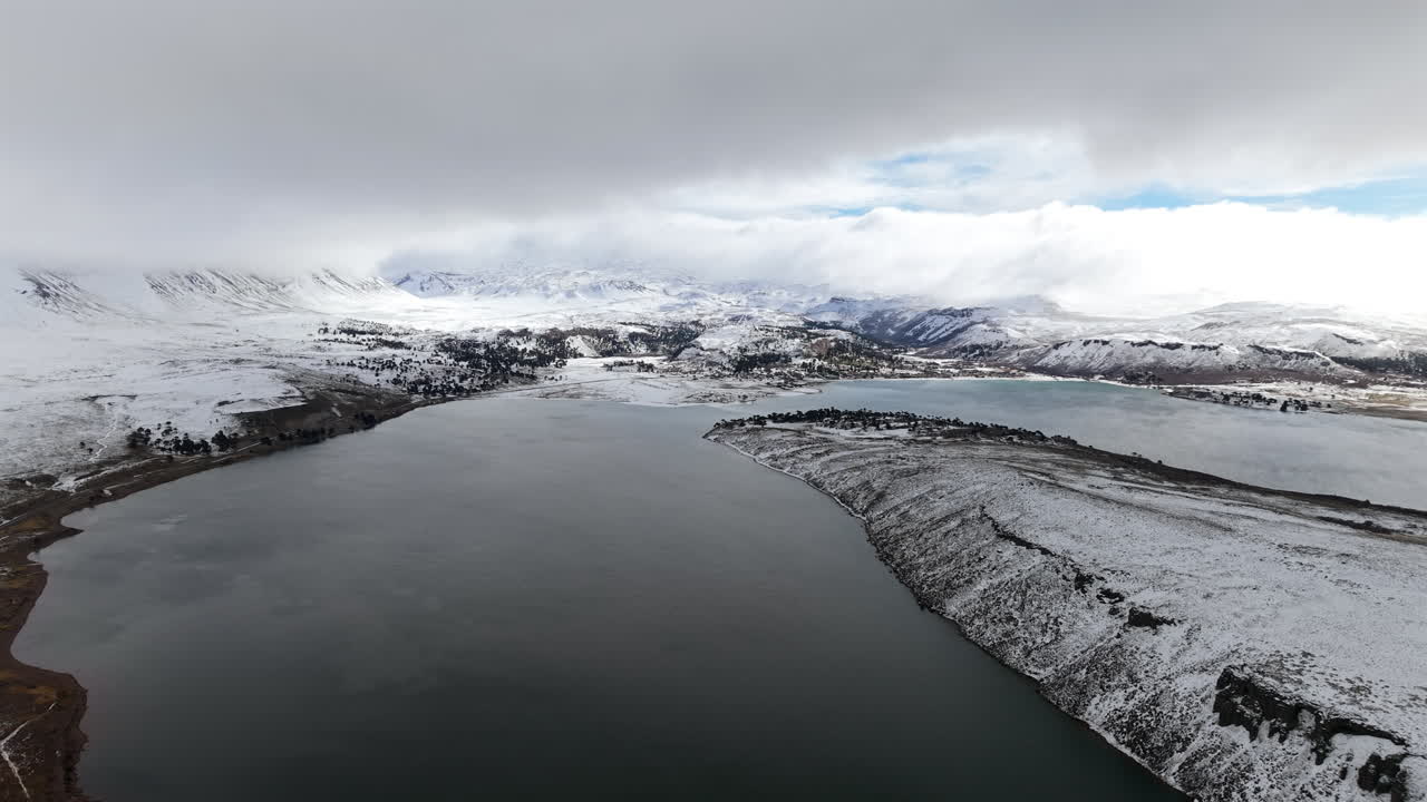Snowy Caviahue lake and dramatic winter clouds over Andes mountains in Argentina