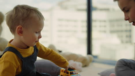 Joyful-siblings-playing-at-home.-Beautiful-brothers-enjoying-indoor-games.