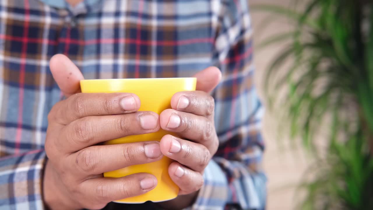 노란색 컵을 들고 있는 사람