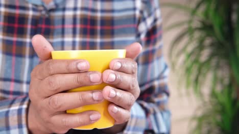 person holding a yellow cup