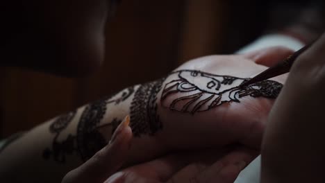 woman mehendi artist painting henna on the hand in agra city, india. - high angle shot