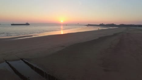 aerial: the boulevard, beach and city of vlissingen during sunset