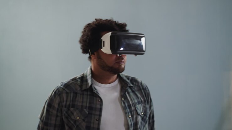 Ragazzo afroamericano con visore VR si gira su sfondo grigio