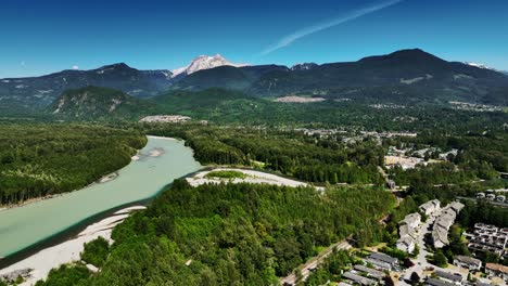 idyllic river with lush vegetation in the neighborhood of squamish, british columbia, canada - aerial shot