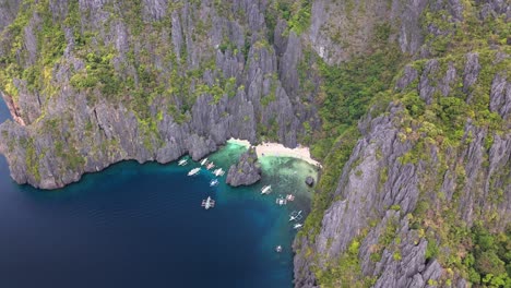bird's-eye survey of the beautiful secret lagoon and jiji's beach with boats, miniloc island, philippines