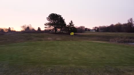 tracking shot moving forward over golf course during sunrise