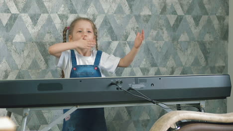 girl with plaits sends air kisses near music synthesizer